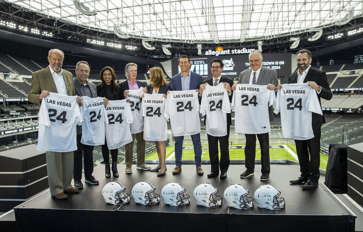 The Las Vegas Super Bowl Host Committee members hold ceremonial jerseys on stage following a pr ...