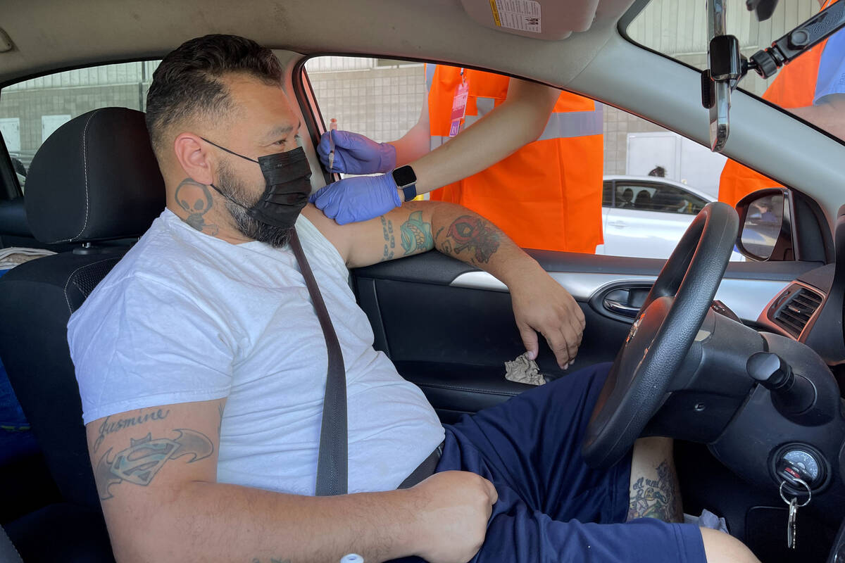 Carlos Montiel of Las Vegas gets his shot during a drive-thru COVID-19 vaccine clinic in the Br ...