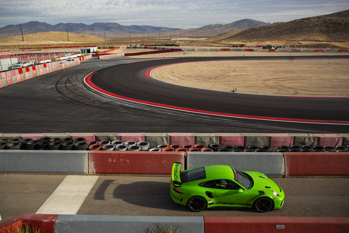 A Porsche 911 GT3 RS drives between safety barriers while exiting the track at Exotics Racing a ...