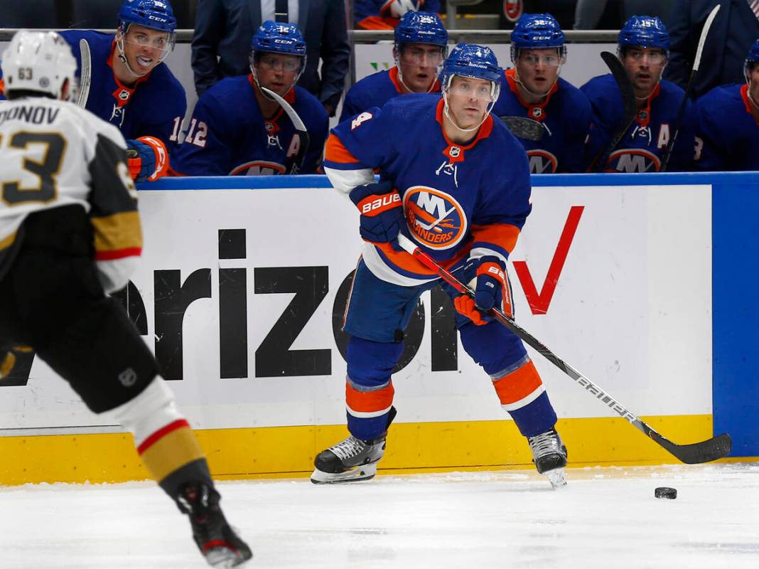 New York Islanders' Andy Greene (4) looks to pass around Vegas Golden Knights' Evgenii Dadonov ...