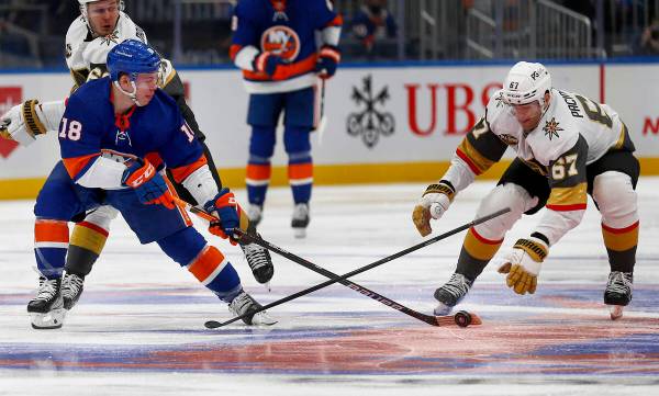 New York Islanders' Anthony Beauvillier (18) reaches for the puck as Vegas Golden Knights' Max ...