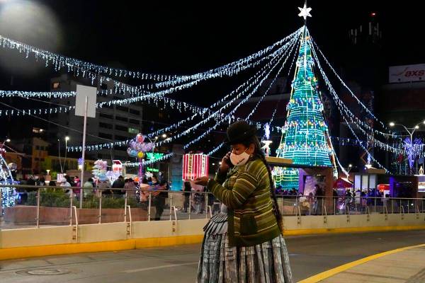 An Aymara woman talks on her cell phone at the Tejada Sorzano square adorned with holiday light ...