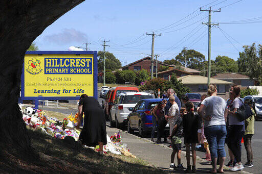 People leave flowers and tributes outside Hillcrest Primary School in Devonport, in the island ...