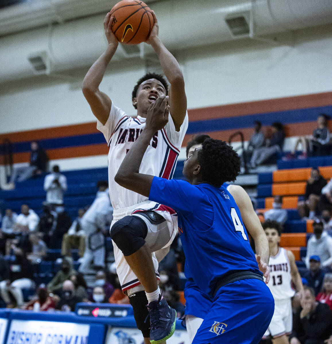 Liberty HighÕs Dedan Thomas (11) goes for the hoop as Bishop GormanÕs Jason Richardso ...