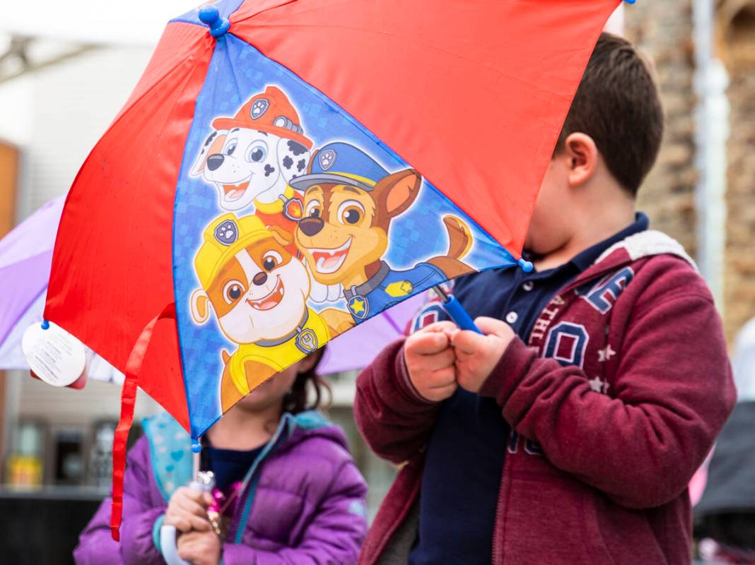 Erika Gannon, 4, left, and her brother Mason, 6, hold umbrellas to protect themselves from rain ...