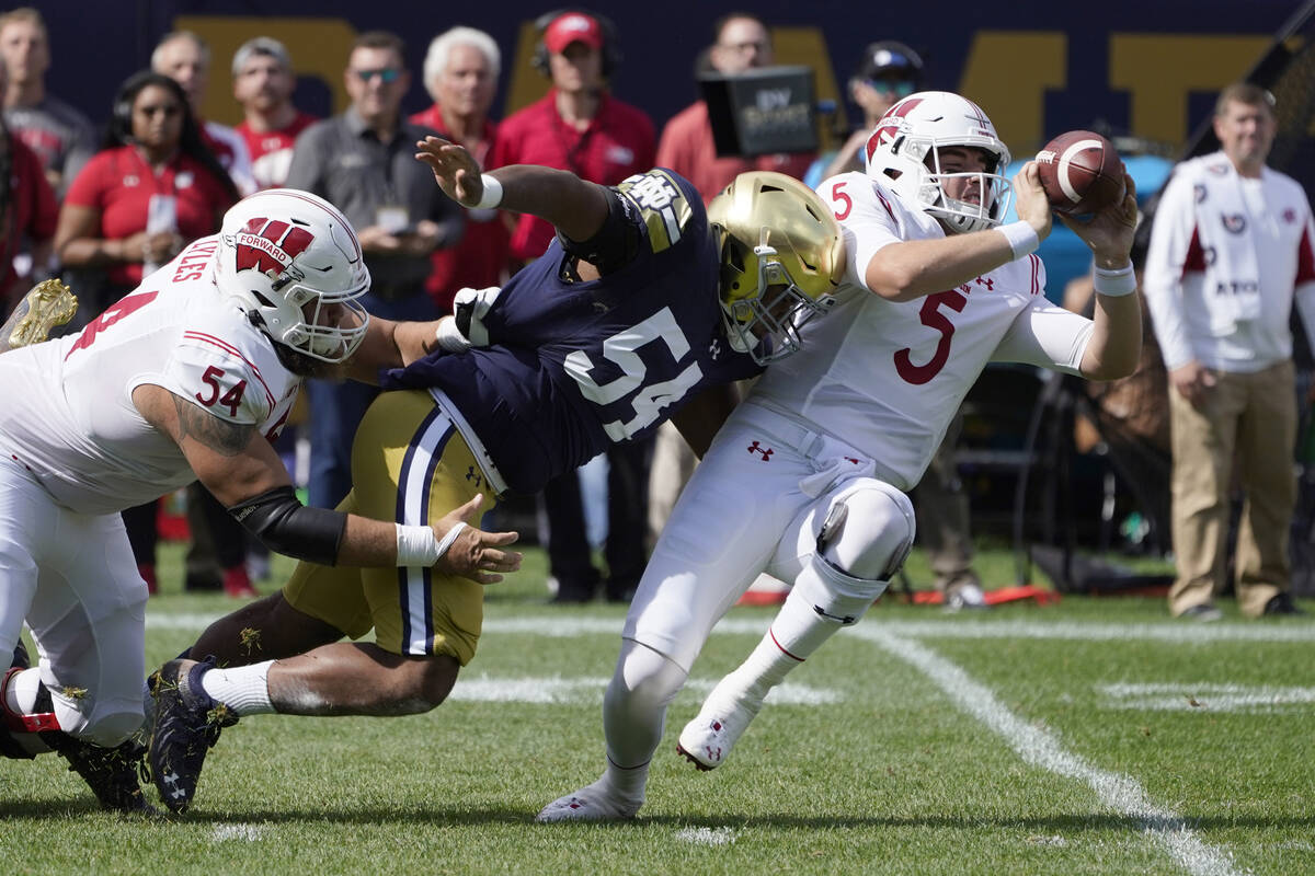 Wisconsin quarterback Graham Mertz (5) makes a two-handed pass to avoid the pressure from Notre ...