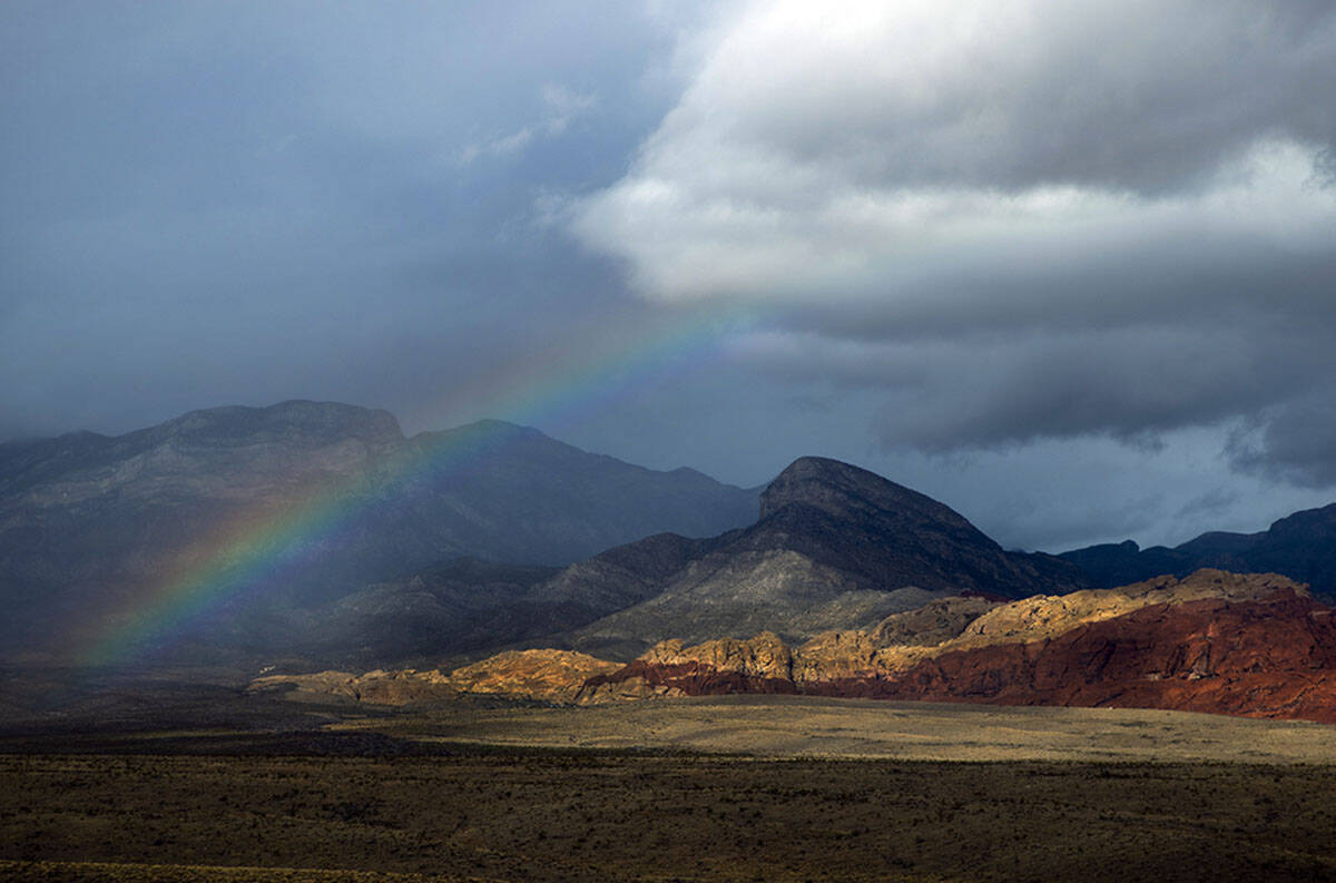 A rainbow appears above the valley floor at the Red Rock Canyon National Conservation Area as r ...