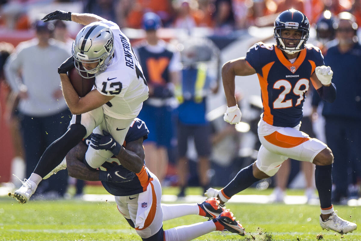 Raiders wide receiver Hunter Renfrow (13) is tackled by Denver Broncos safety Kareem Jackson (2 ...