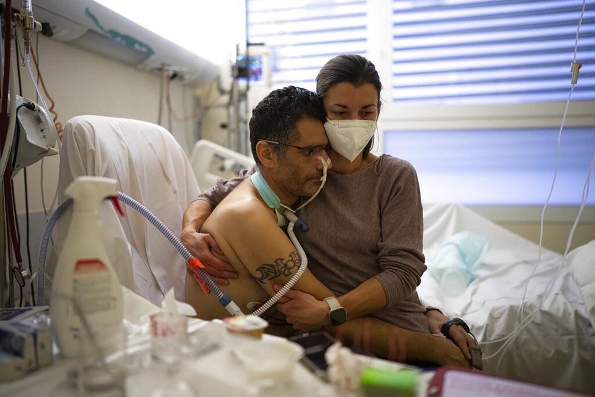 Amelie and Ludo Khayat hold each other during a visit at the COVID-19 intensive care unit of th ...