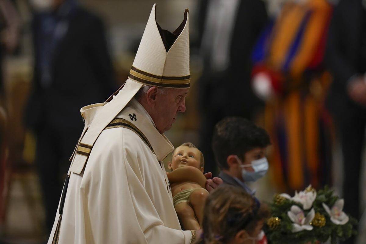 Pope Francis carries a statue of Baby Jesus as he celebrates Christmas Eve Mass, at St. Peter's ...