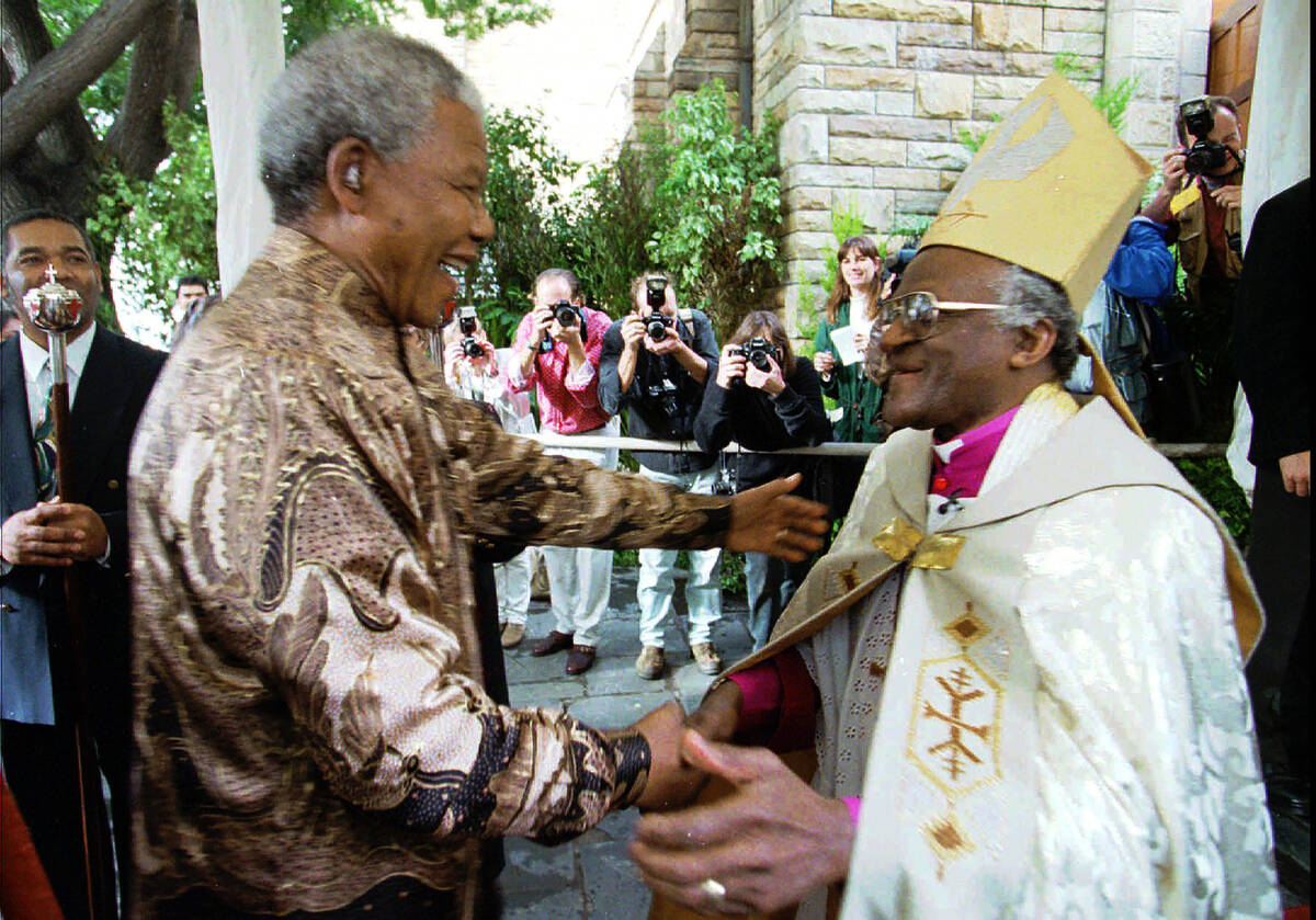 FILE - Retiring Archbishop of Cape Town Desmond Tutu, right, greets President Nelson Mandela at ...
