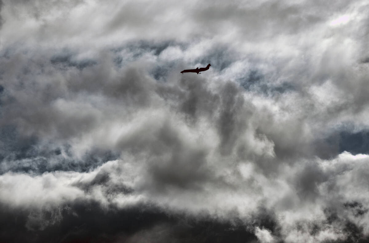 An airliner takes an approach through storm clouds to Hollywood Burbank Airport, in Burbank, Ca ...