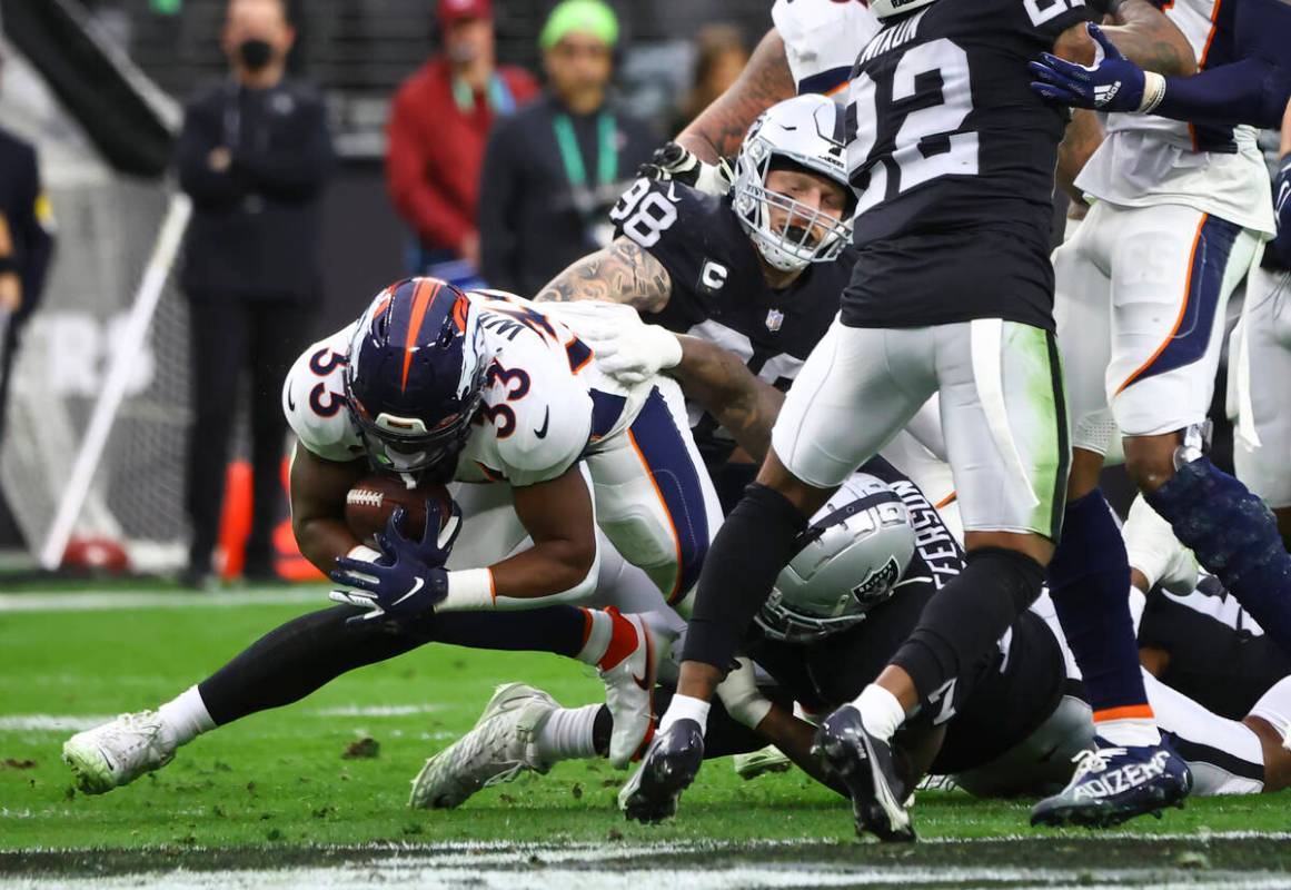 Raiders defensive tackle Quinton Jefferson (77) tackles Denver Broncos running back Javonte Wil ...