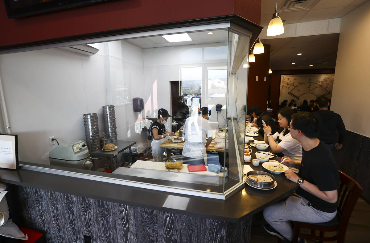 People dine as employees cook food at ShangHai Taste in Chinatown’s Shanghai Plaza in La ...
