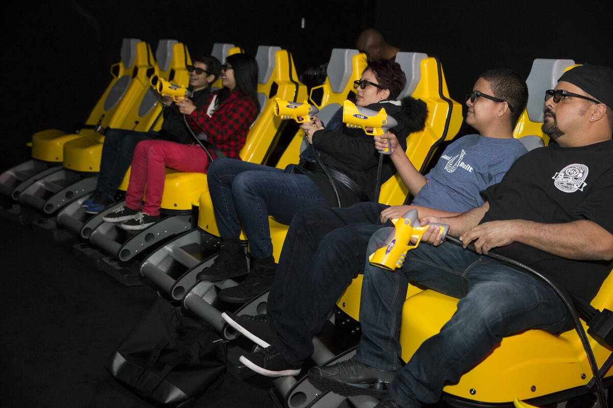 Bryan Fernandez, from right, his son Bryson and wife Leila experience the XD Dark Ride at GameW ...