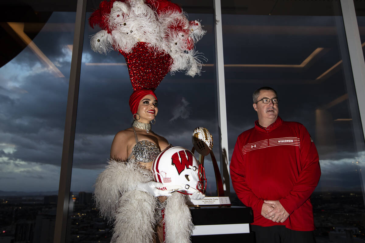 Wisconsin coach Paul Chryst, right, poses with showgirl Porsha Revesz during a media event at C ...