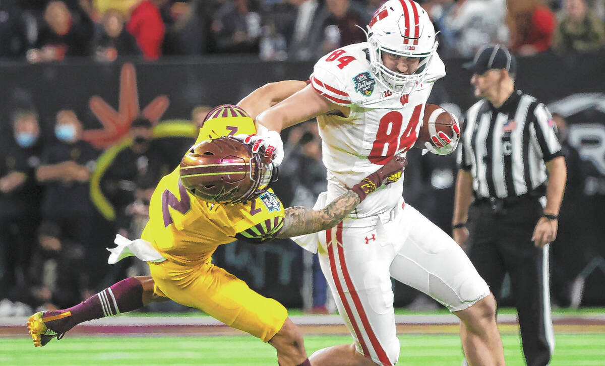 Wisconsin Badgers tight end Jake Ferguson (84) stiff-arms Arizona State Sun Devils defensive ba ...