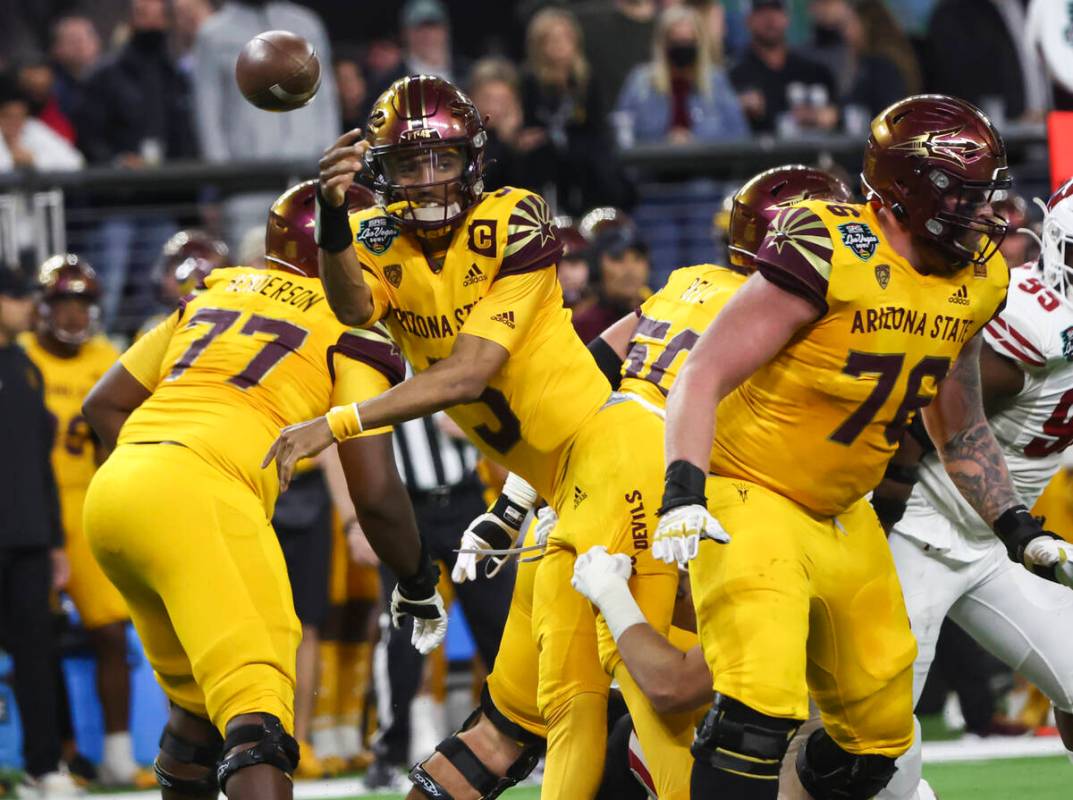 Arizona State Sun Devils quarterback Jayden Daniels (5) throws a pass while being tackled by th ...