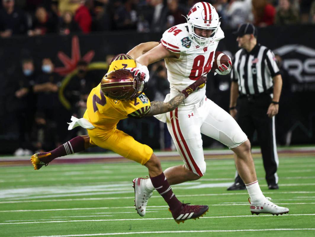 Wisconsin Badgers tight end Jake Ferguson (84) stiff-arms Arizona State Sun Devils defensive ba ...