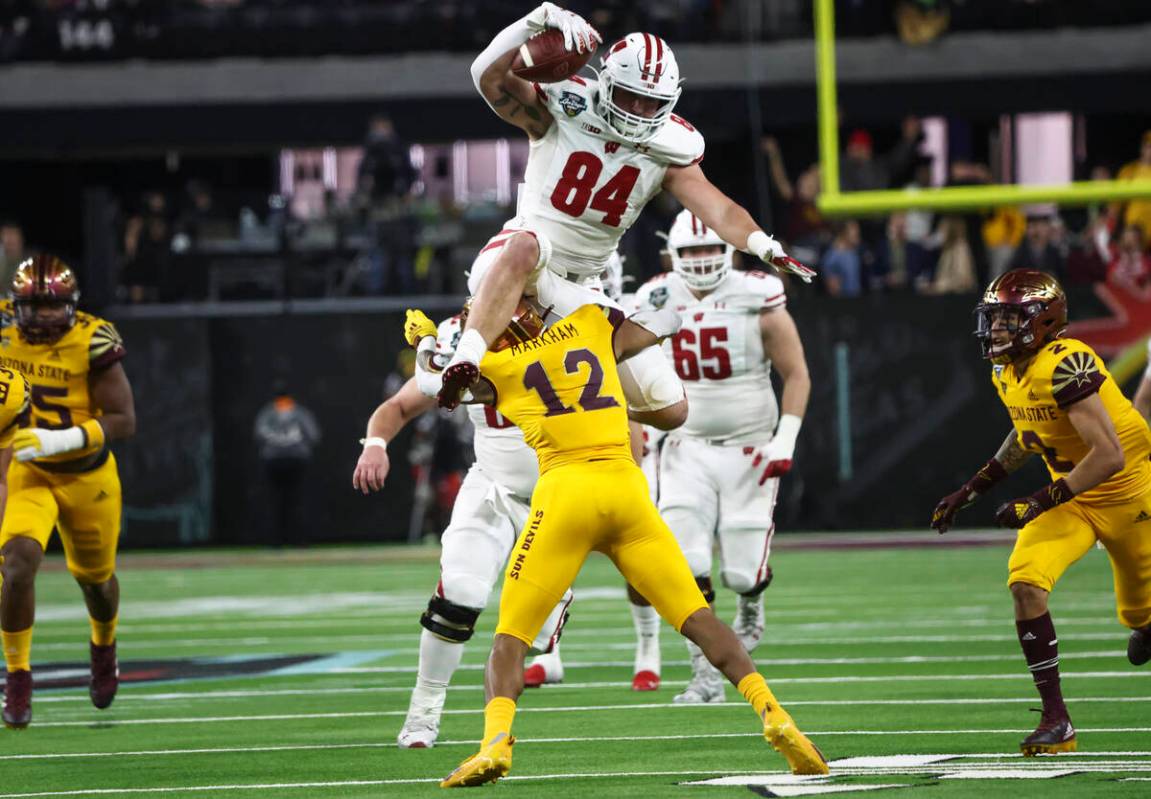 Wisconsin Badgers tight end Jake Ferguson (84) leaps over Arizona State Sun Devils defensive ba ...