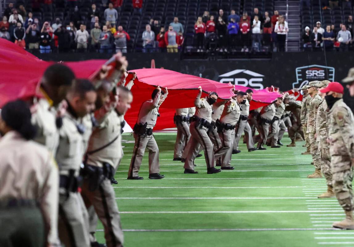 Las Vegas police officers display the U.S. flag across the field before the Las Vegas Bowl NCAA ...