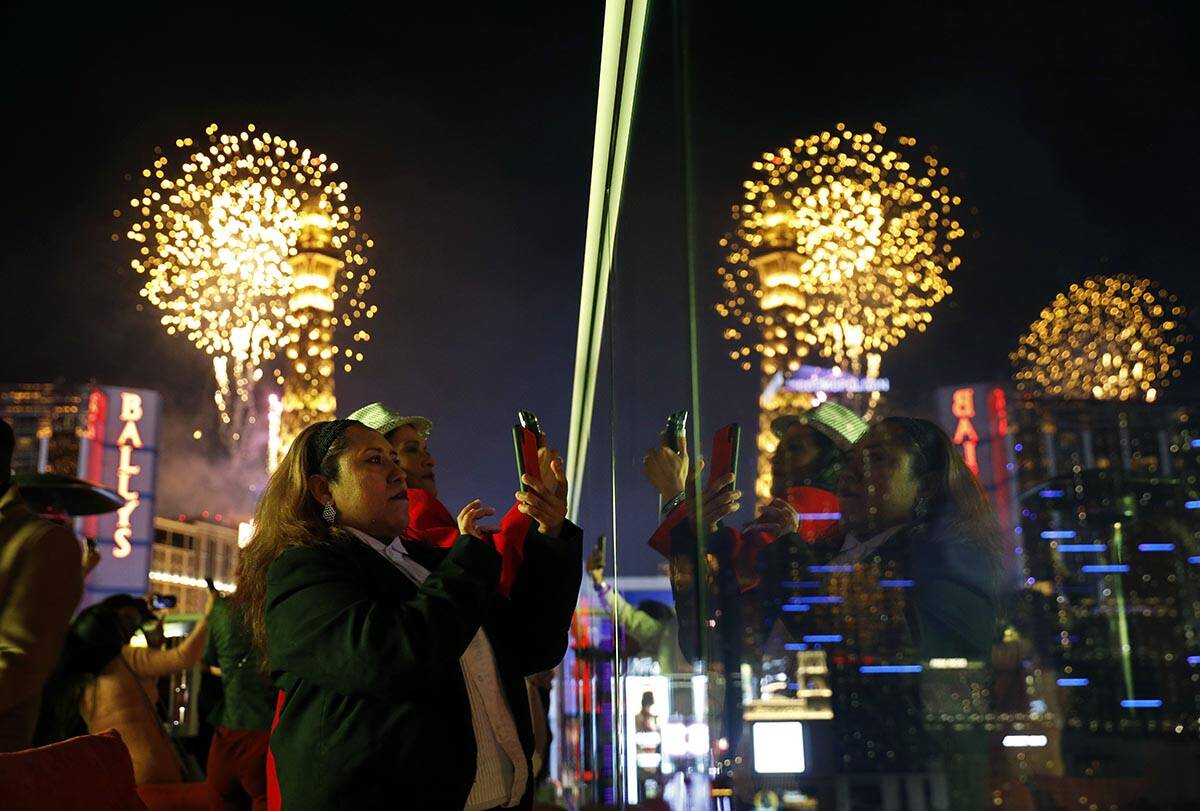 Revelers watch at Drai's nightclub as fireworks explode on the Las Vegas Strip during a New Yea ...