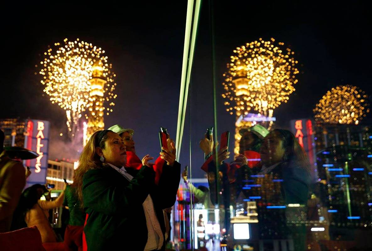 Revelers watch at Drai's nightclub as fireworks explode on the Las Vegas Strip during a New Yea ...