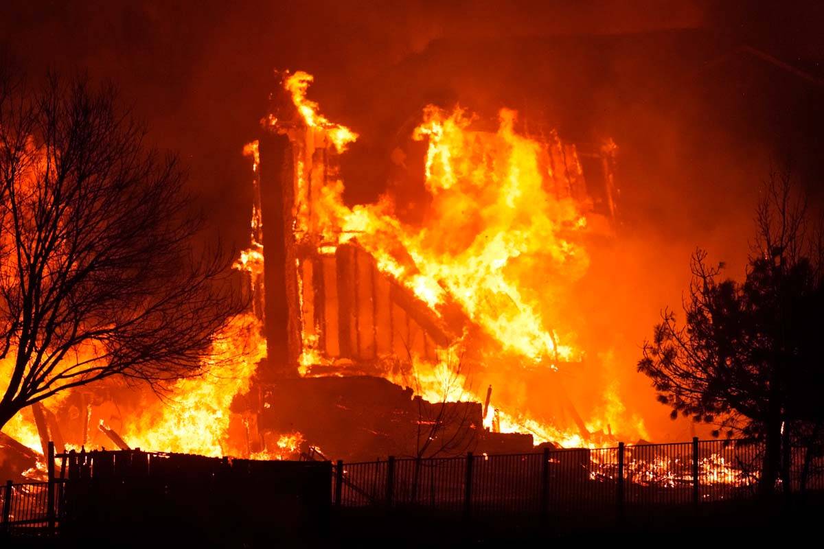 Homes burn as a wildfire rips through a development near Rock Creek Village, Thursday, Dec. 30, ...