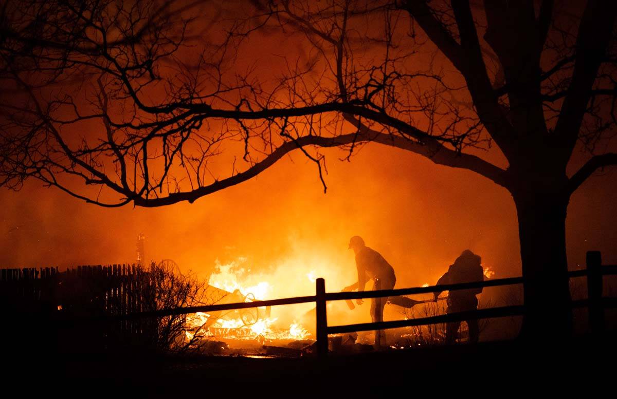 Residents fight the Marshall Fire in Louisville, Colo., Thursday, Dec. 30, 2021, as fire crews ...