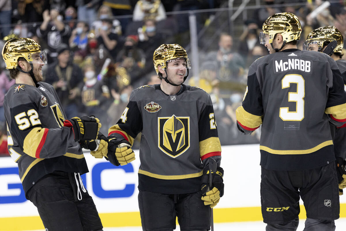 Golden Knights center Adam Brooks (24) celebrates with defenseman Dylan Coghlan (52) and defens ...