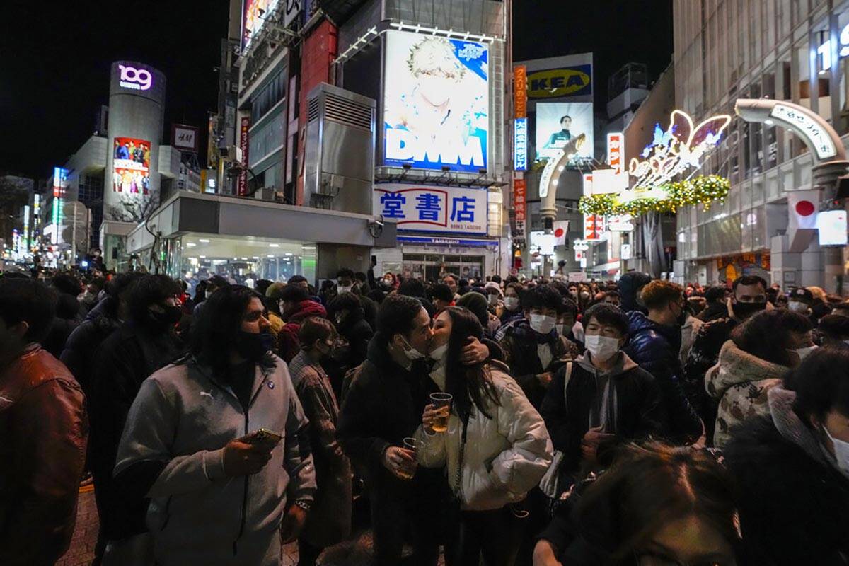 A couple kiss as people celebrate the arrival of the new year at the famed Shibuya scramble cro ...
