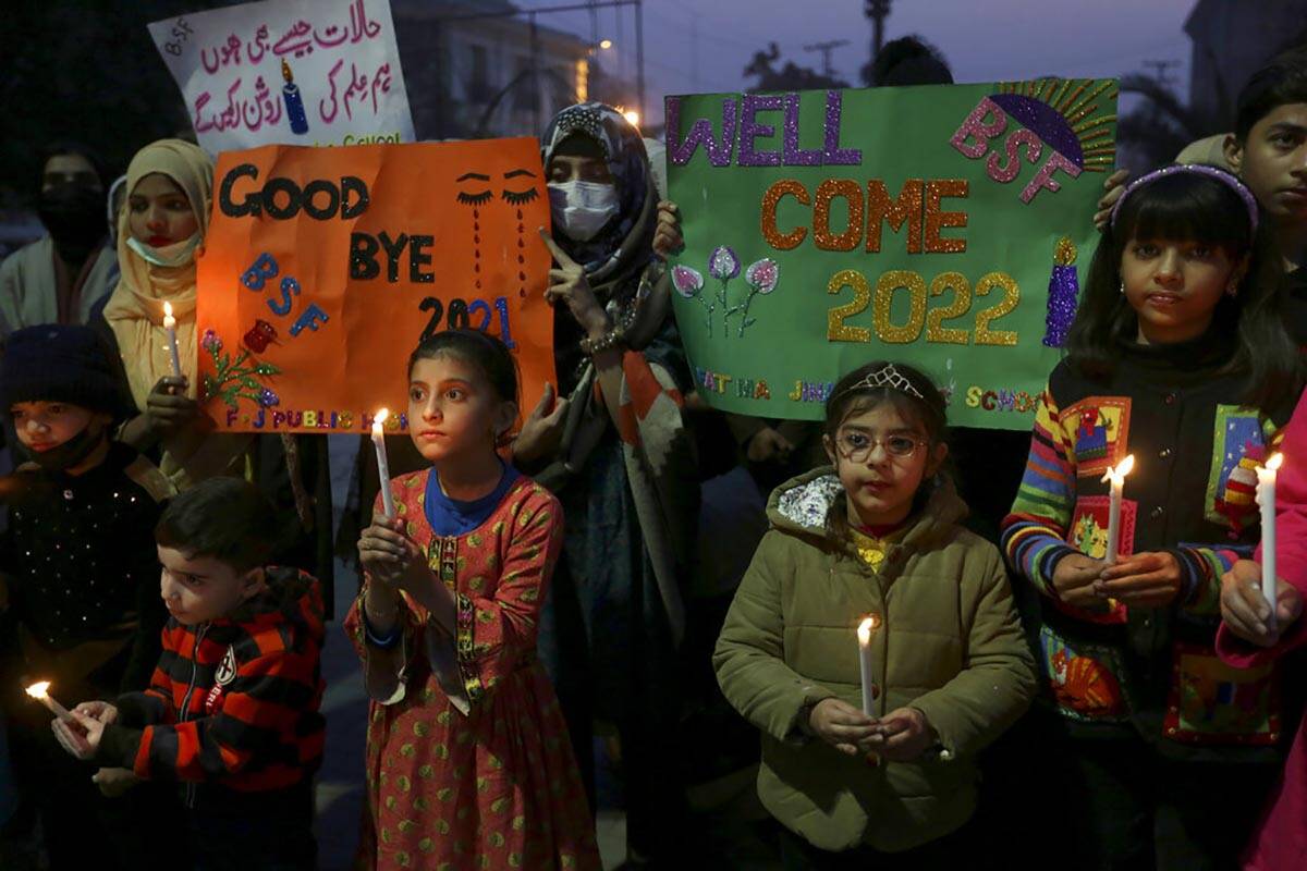 Students holds candles while participating in a demonstration to say goodbye to year 2021 and w ...