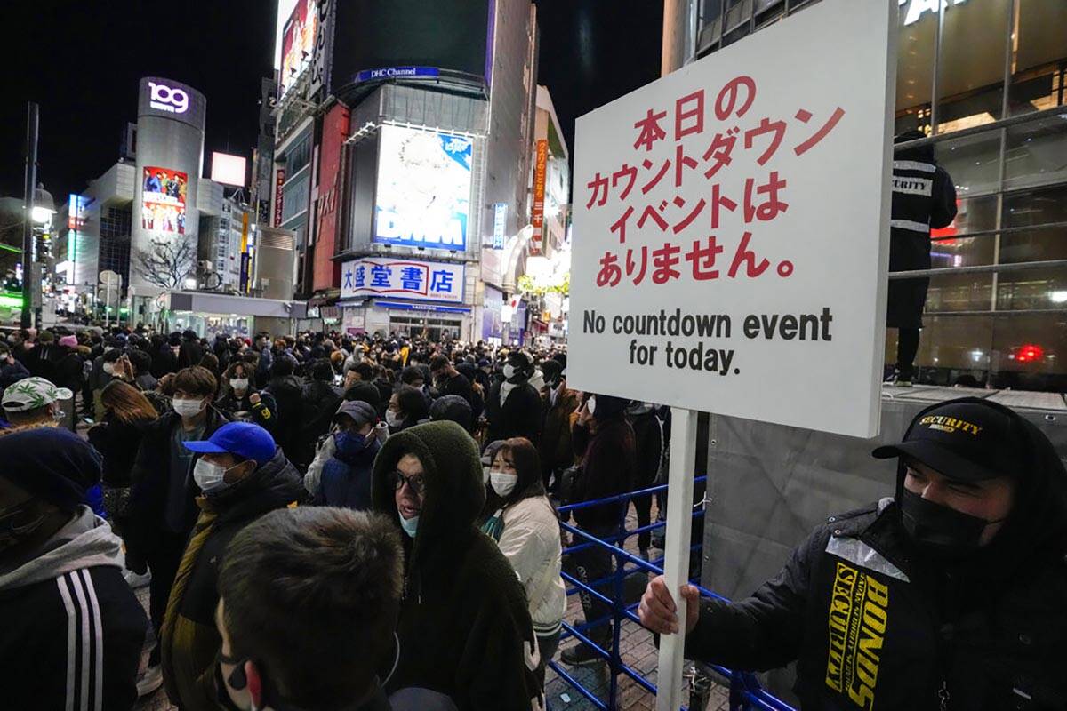 A security guard holds up a sign indicating that there is no countdown event at the famed Shibu ...