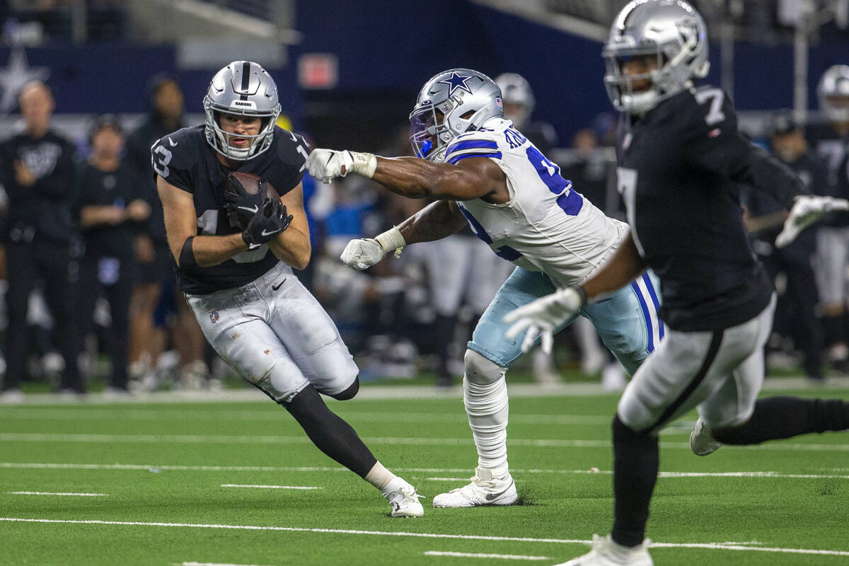 Raiders wide receiver Hunter Renfrow (13) looks for room to run as Dallas Cowboys defensive end ...