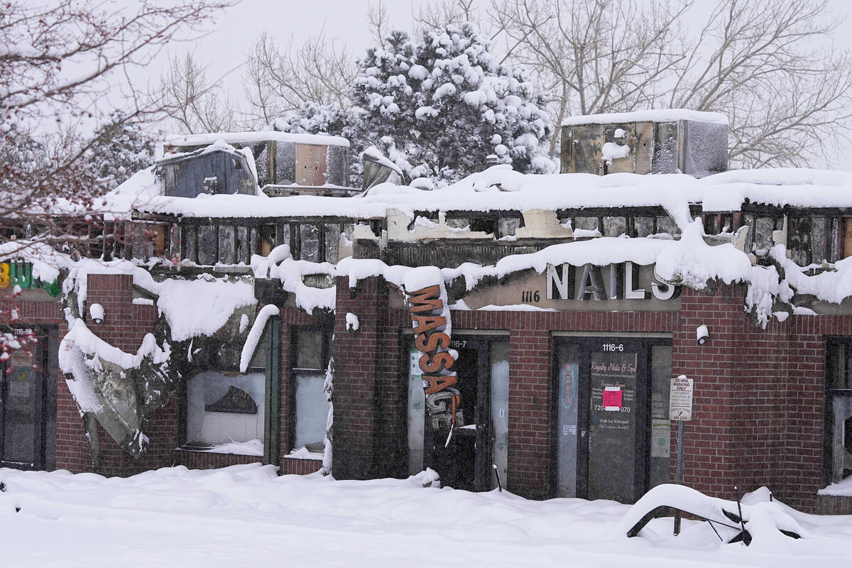 Snow covers the burned remains of a shopping center after the Marshall Wildfire Saturday, Jan.1 ...