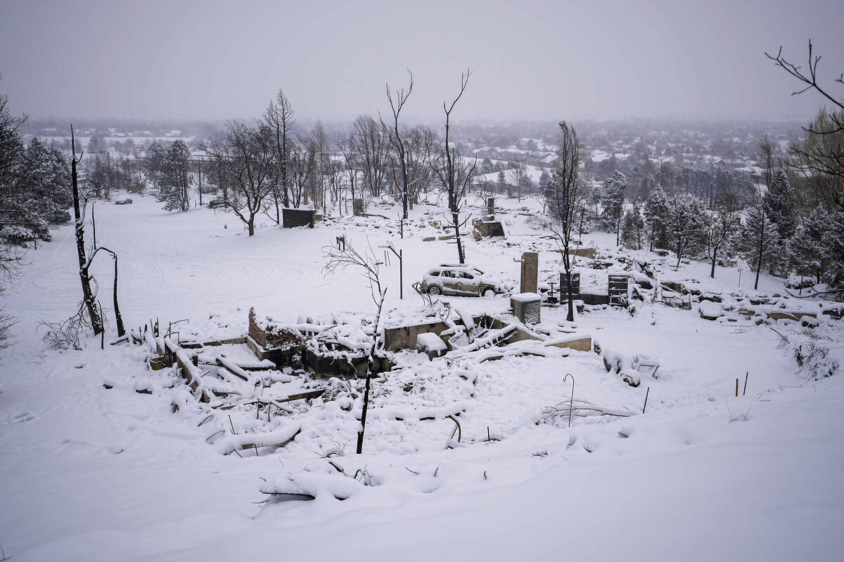 Snow covers the burned remains of homes in Louisville, Colo., on Saturday, Jan.1, 2022, after t ...