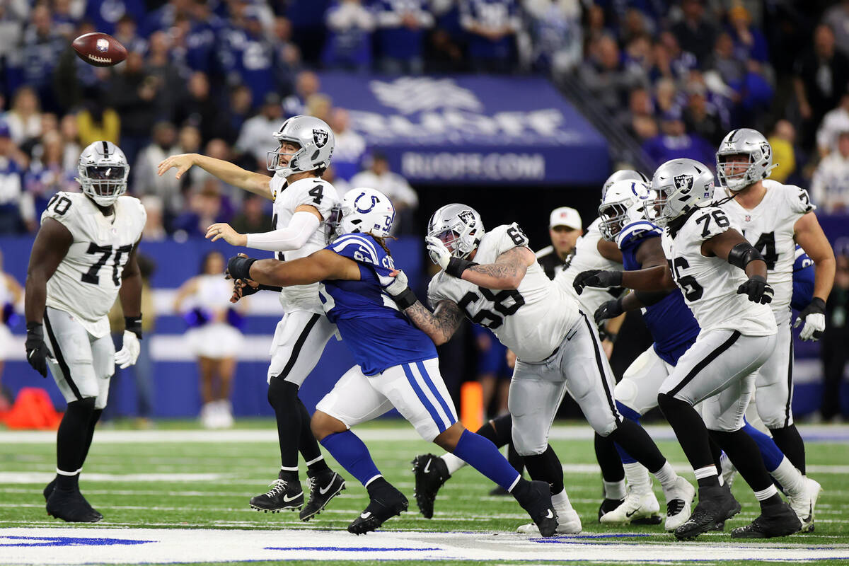 Raiders quarterback Derek Carr (4) makes a pass under pressure from Indianapolis Colts defensiv ...