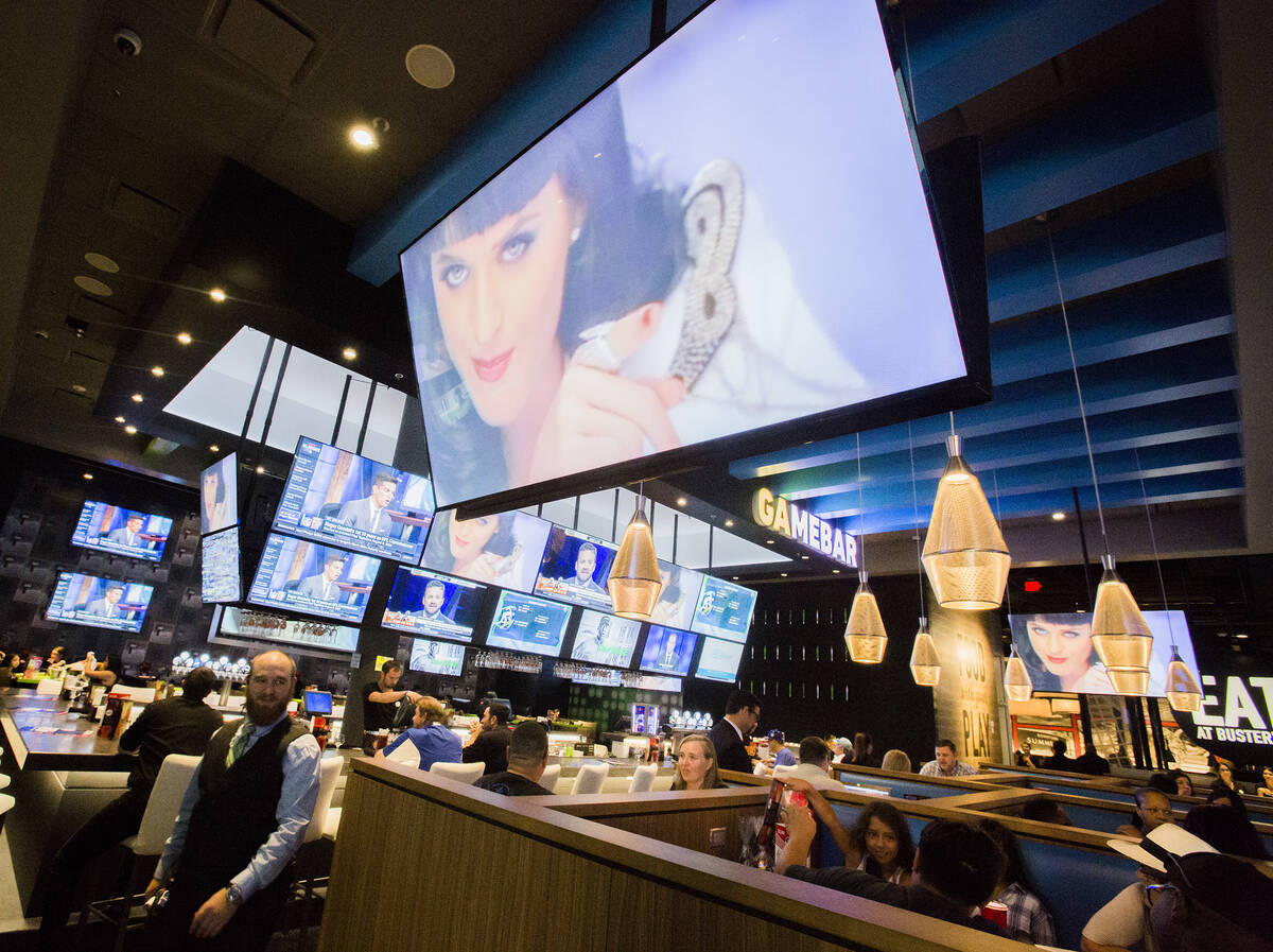 Multiple television screens showing sports and music video is seen at Dave and Buster's in Down ...