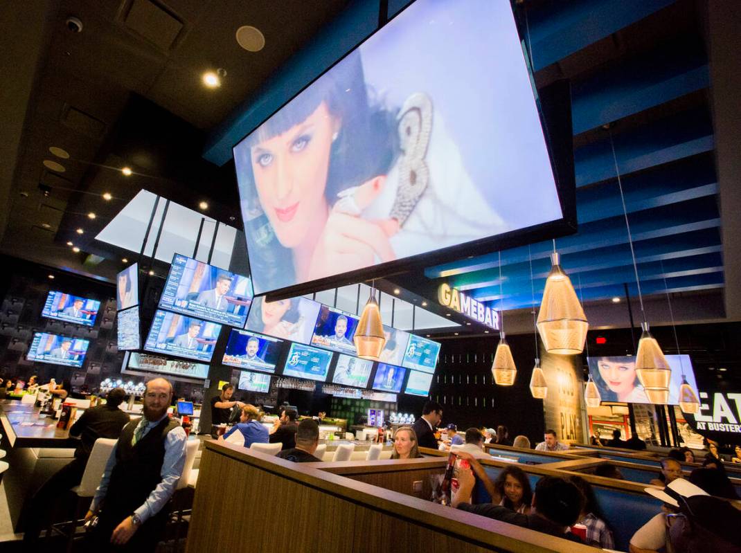 Multiple television screens showing sports and music video is seen at Dave and Buster's in Down ...