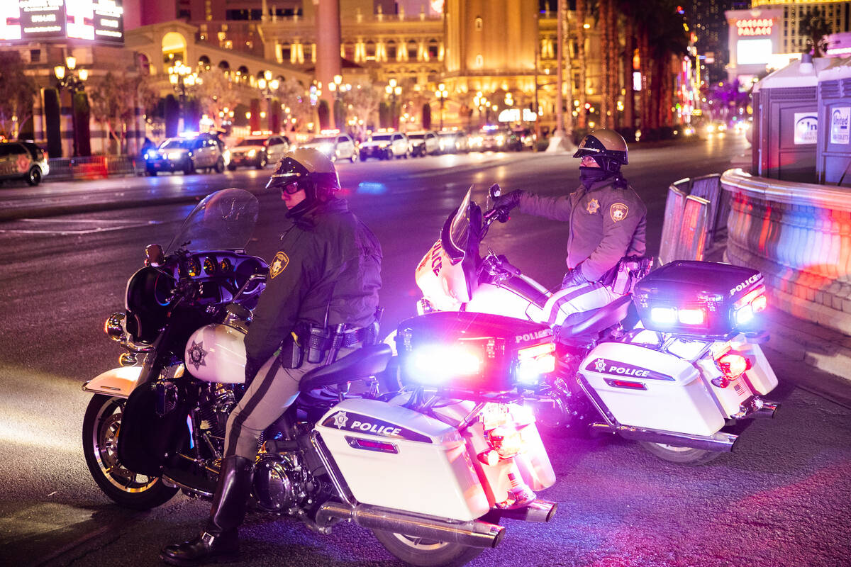 Law enforcement watch New Year’s Eve crowds walk the Strip on Friday, Dec. 31, 2021, in ...