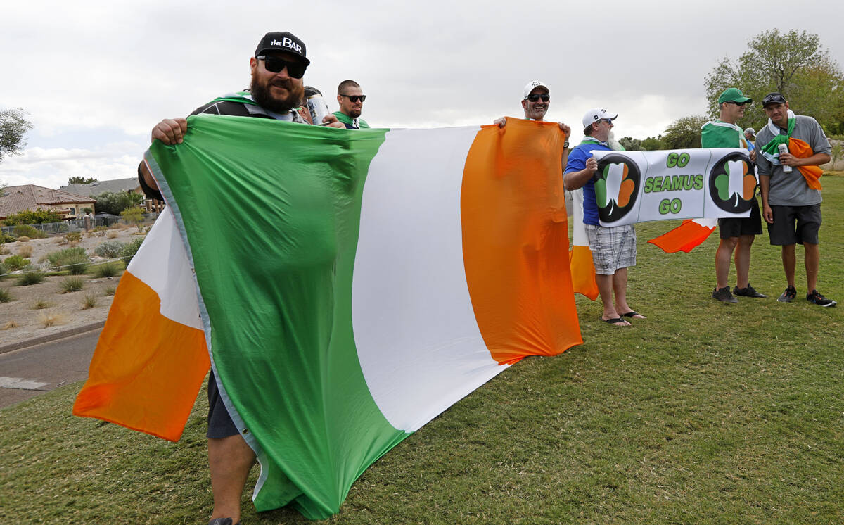 Seamus Power's fans hold Irish flags during his play on the 12th green during the third round o ...