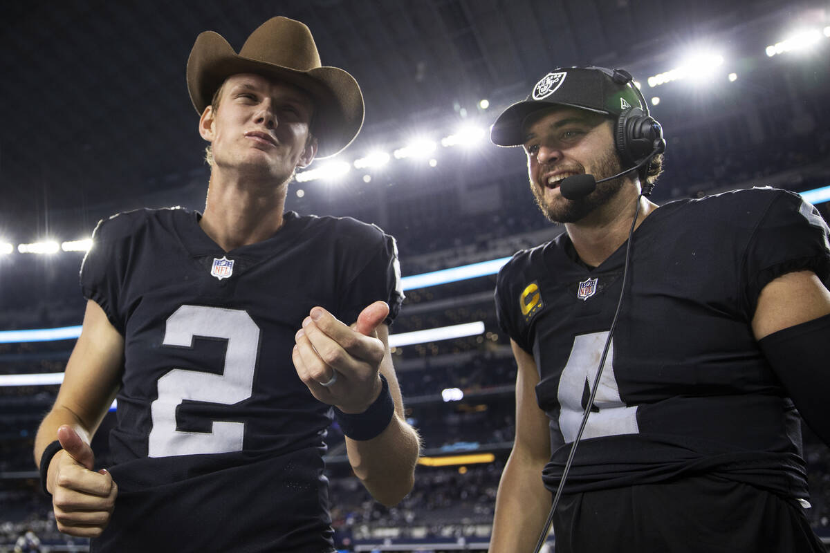 Raiders kicker Daniel Carlson (2) celebrates with Raiders quarterback Derek Carr (4) by eating ...