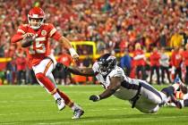 Kansas City Chiefs quarterback Patrick Mahomes (15) scrambles away from Denver Broncos defensiv ...