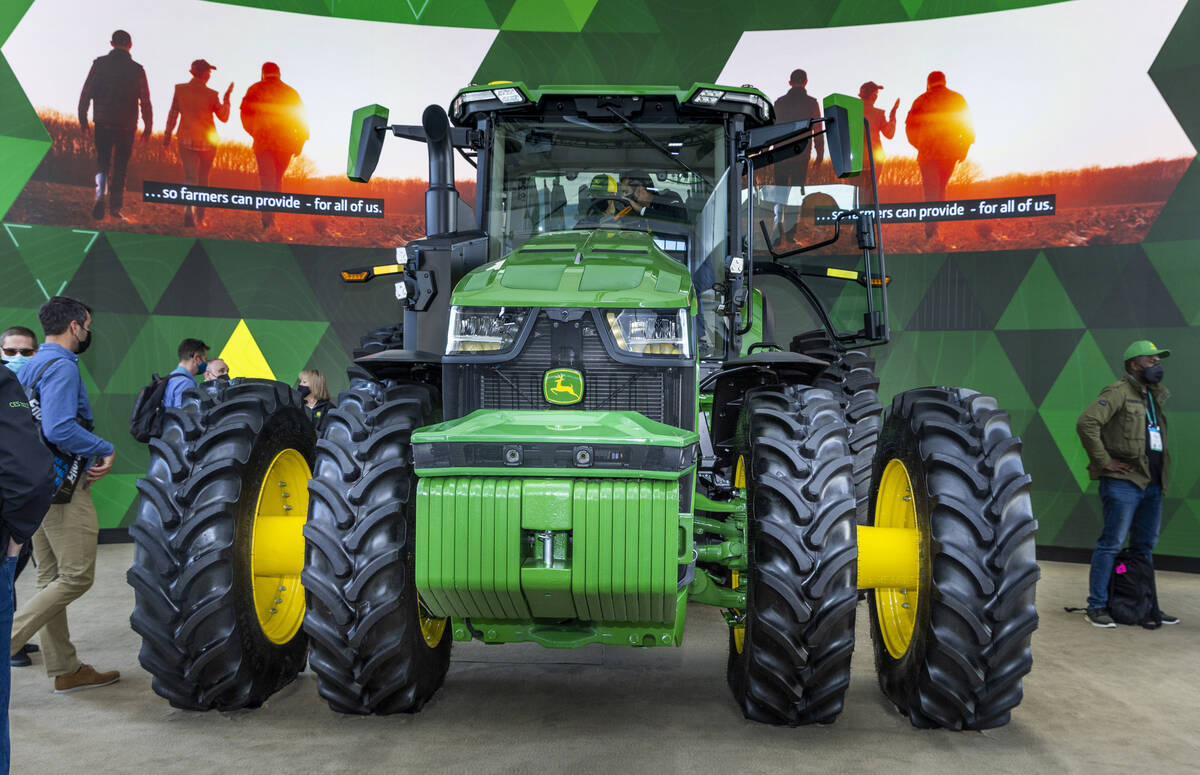 Attendees check out a John Deere fully autonomous 8R tractor during the first day of CES at the ...