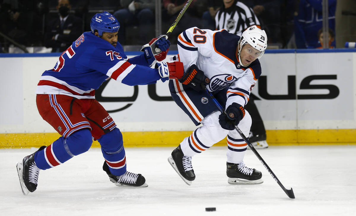 New York Rangers' Ryan Reaves (75) and Edmonton Oilers' Slater Koekkoek (20) battle for the puc ...