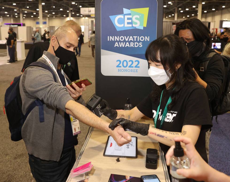 Chaeyi Kim gives a Prinker digital temporary tattoo to Davide Marchini of Las Vegas during the ...