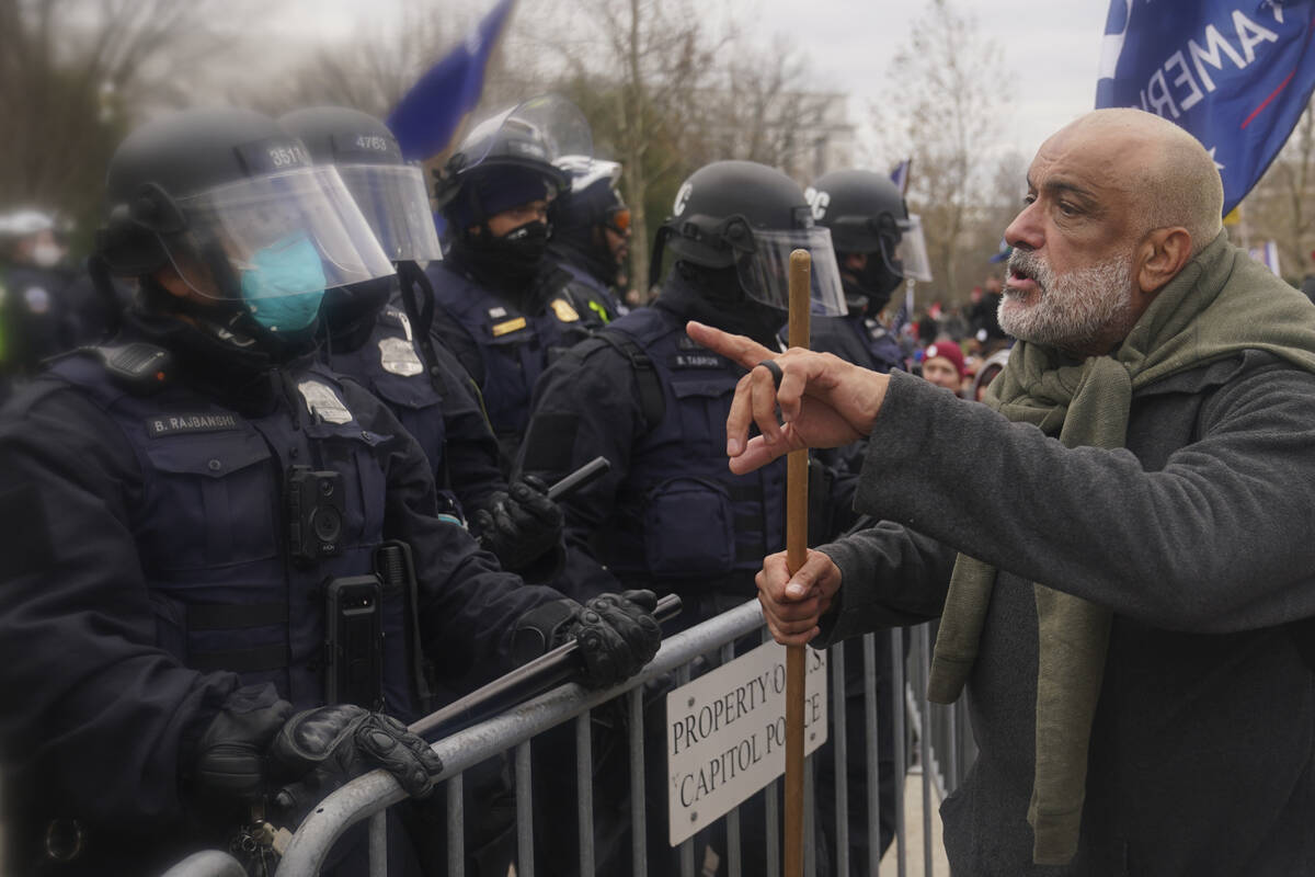 A protester confronts Washington Metropolitan Police department officers as they assist U.S. Ca ...
