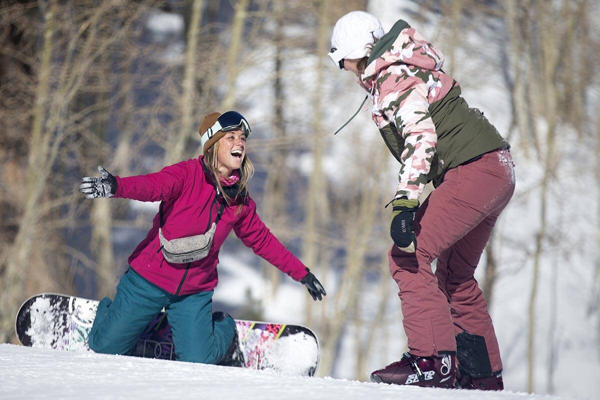 Michelle Meyer, of Las Vegas, slaps hands with her friend Kylee Schraft as they take on jumps a ...