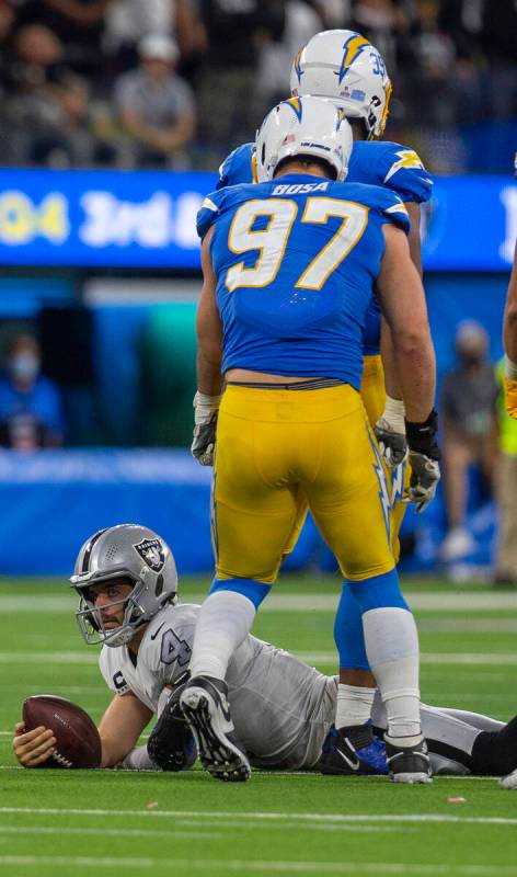 Raiders quarterback Derek Carr (4) stays down after being sacked by Los Angeles Chargers defens ...