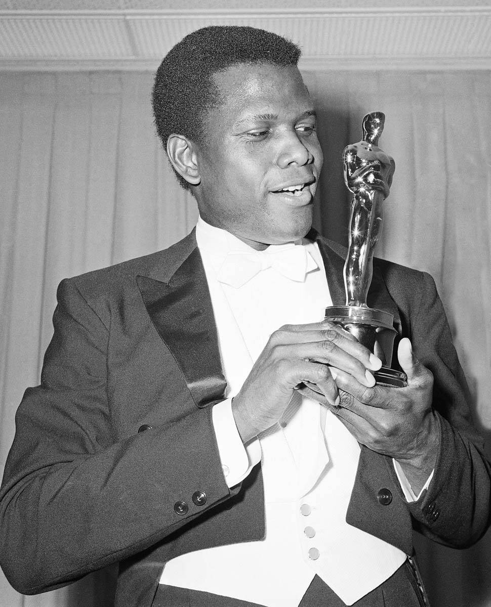 Actor Sidney Poitier poses with his Oscar for best actor for "Lillies of the Field" at the 36th ...